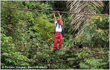 Children use high wires to cross the river, 30 feet below, to get to school in Padang, Indonesia