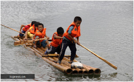 Elementary school students row a raft to school in Gulong township, Southwest China