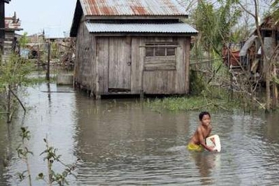 A child plays in flood water, from Cyclone Nargis, 30 km (19 miles) from the centre of Yangon in this handout photograph taken May 9, 2008. REUTERS/Joe Lowry/International of Red Cross and Red Crescent Societies/Handout (MYANMAR).